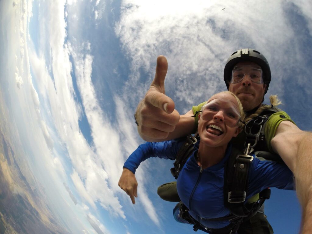 Tandem skydivers double thumbs up